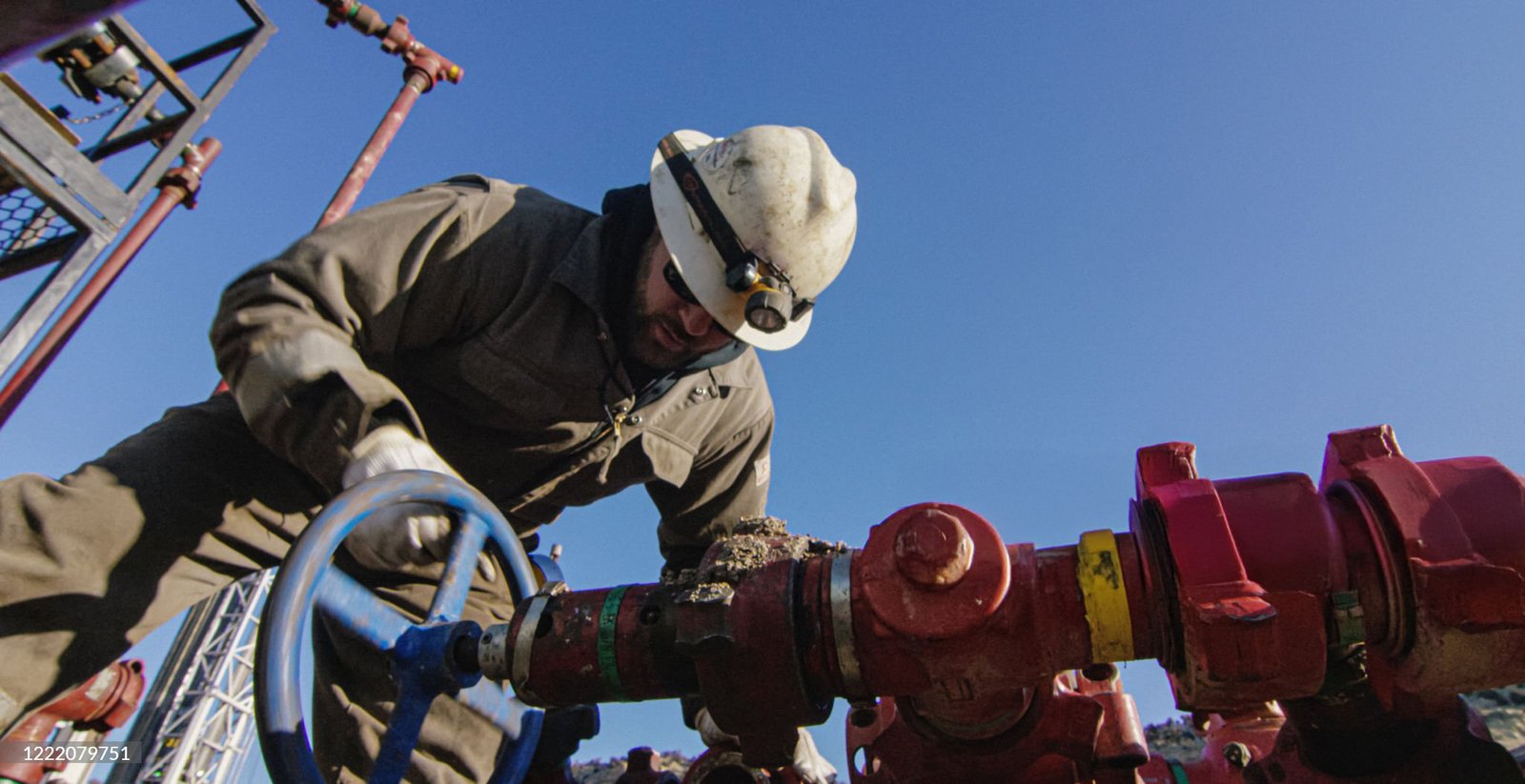 An Oilfield Worker in His Thirties Pumps Down Lines at an Oil and Gas Drilling Pad Site on a Cold, Sunny, Winter Morning